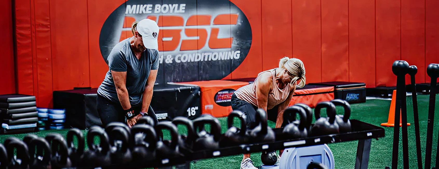 People exercising with kettlebells in gym